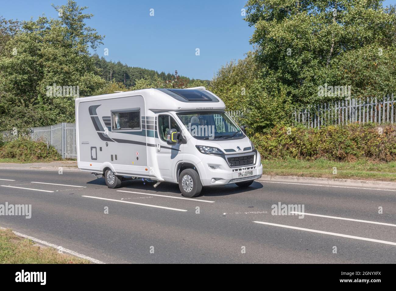Auto-Sleeper Broadway motorhome travelling uphill on country road in Cornwall. For UK motorhomes, campervans, staycations in UK, alternative holidays. Stock Photo