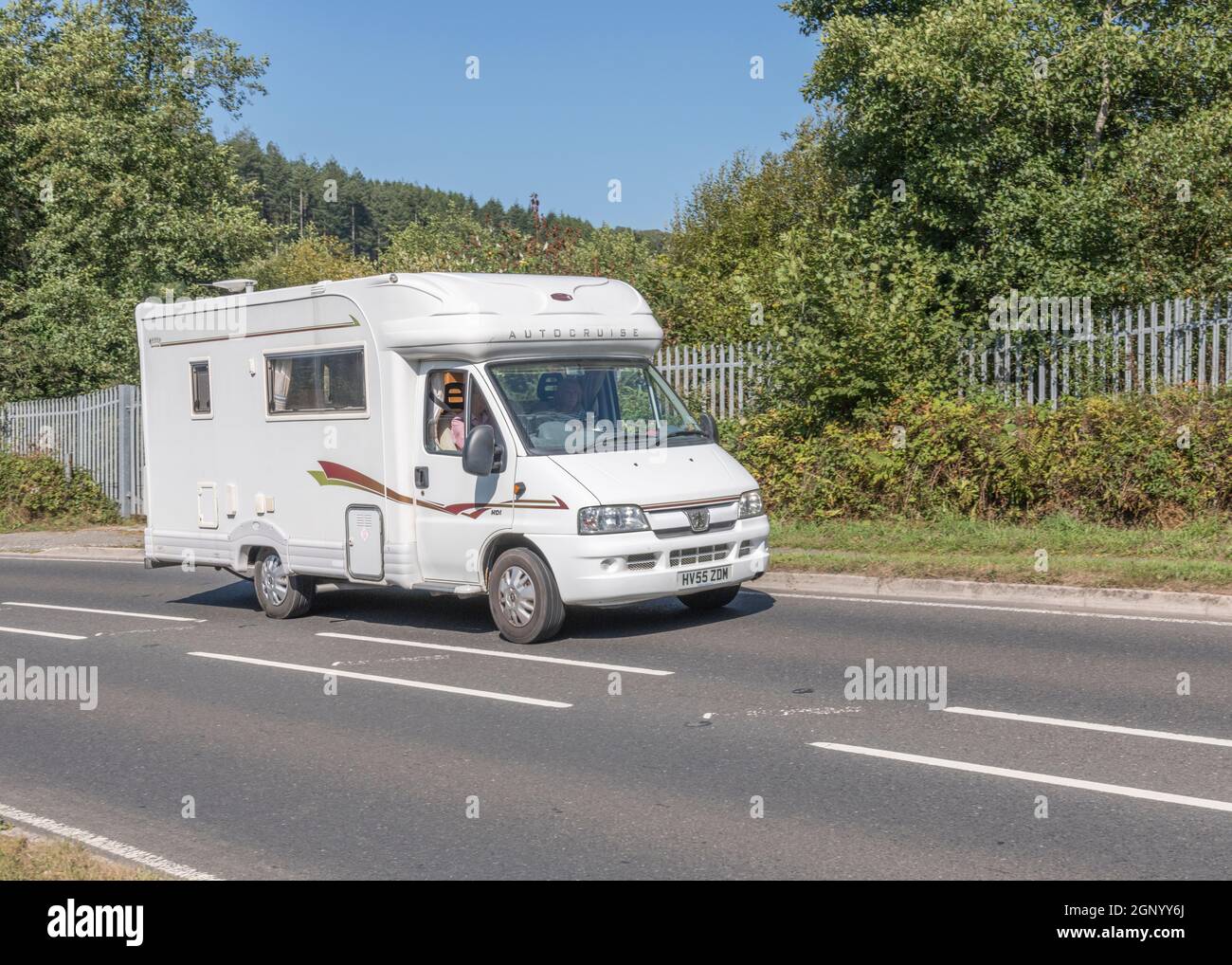 Motorhome travelling uphill on country road in Cornwall. For UK motorhomes, campervans, staycations in UK, alternative holidays. Stock Photo