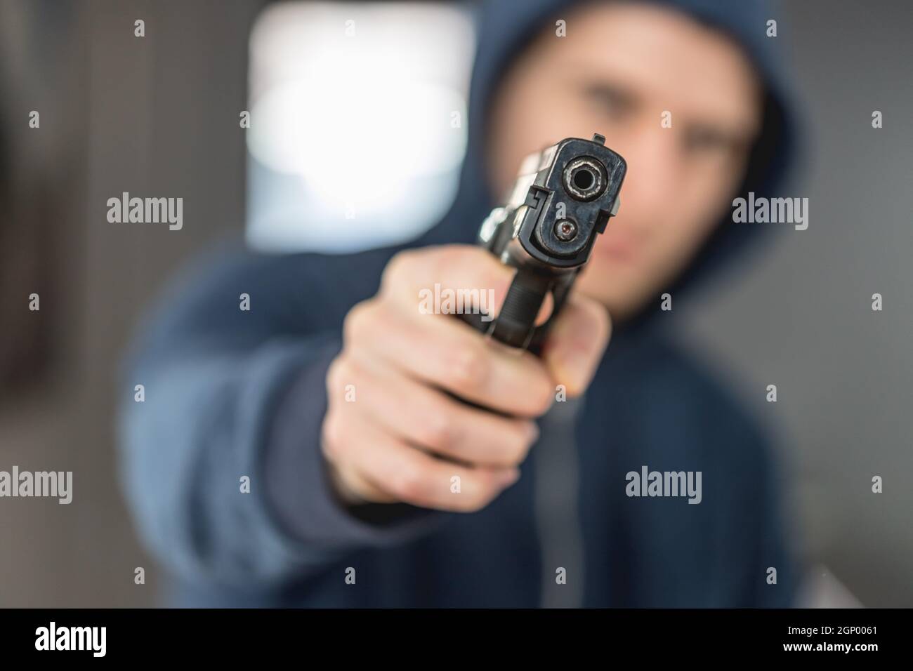 Robbery in store. Robber is aiming and threatening with gun in shop. Stock  Photo