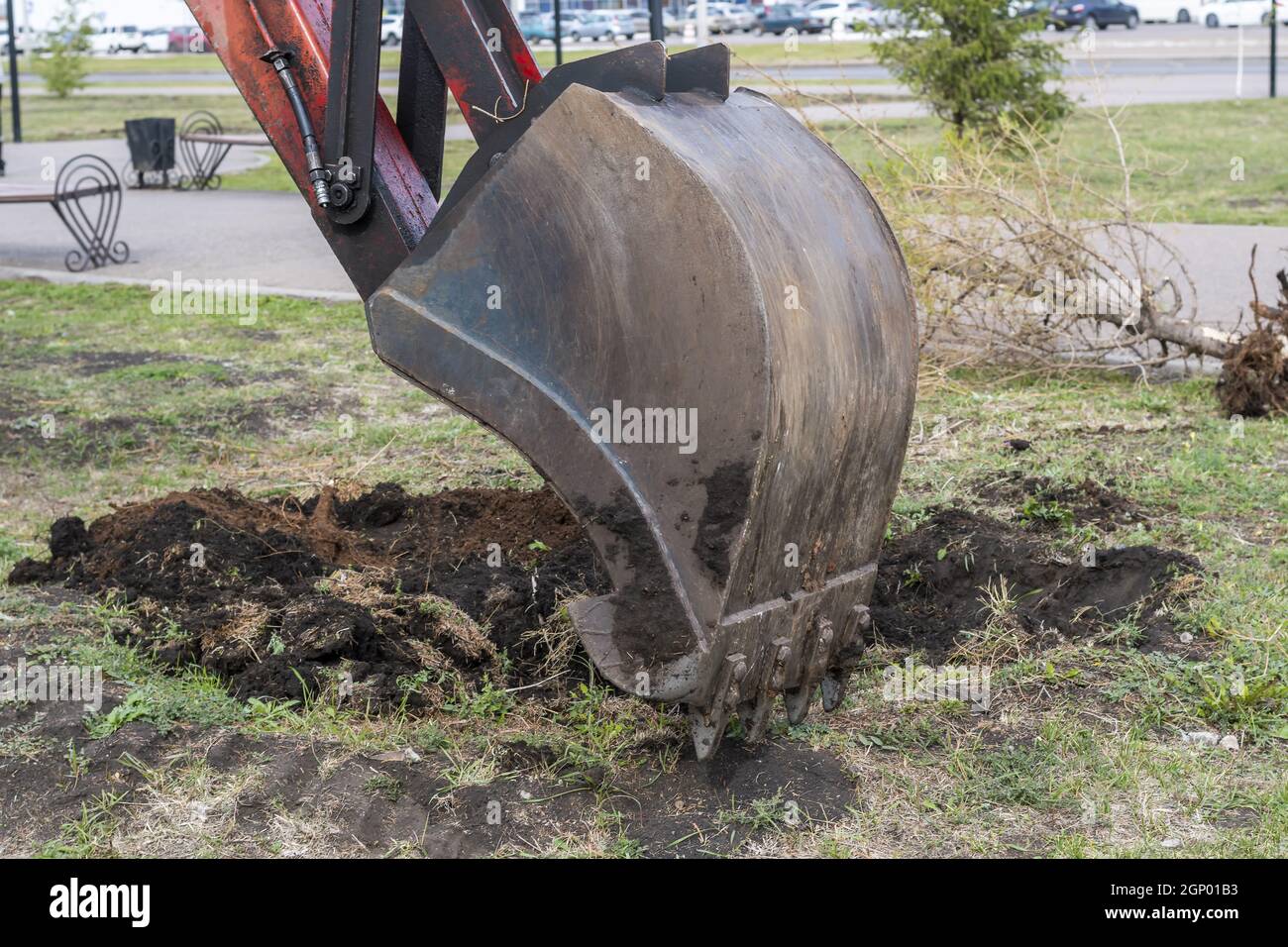Excavator work. The iron ladle digs into the ground. Digging a hole ...