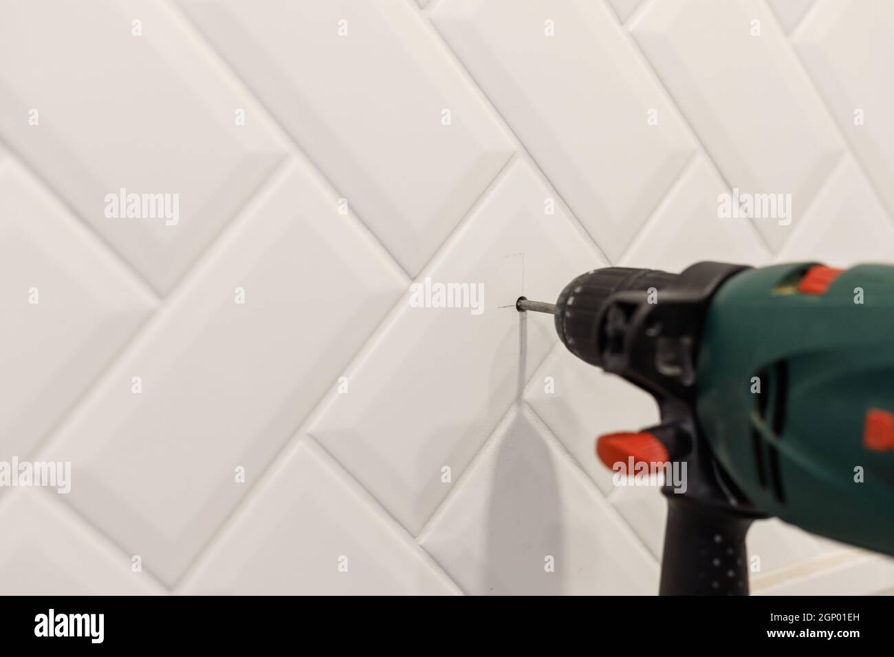 Drilling hole in ceramic tiles on the wall of bathroom. Close up view Stock Photo Alamy
