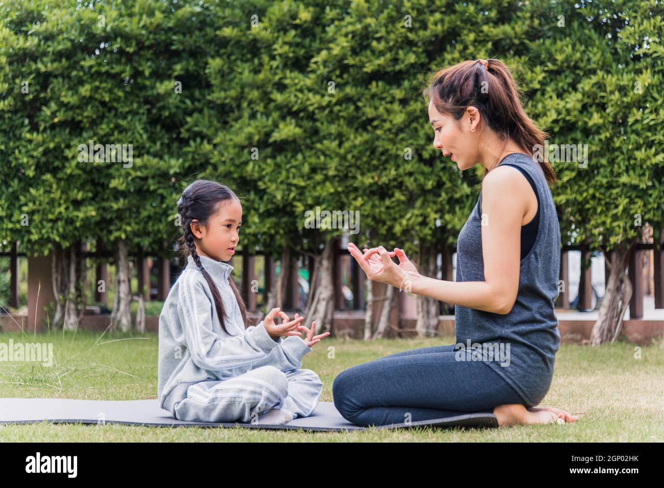 Mother and daughter doing yoga. woman and child training in the park.  outdoor sports. healthy sport lifestyle, chaturanga pose. well being,  mindfulness concept,watching video tutorial online on laptop 8497445 Stock  Photo at