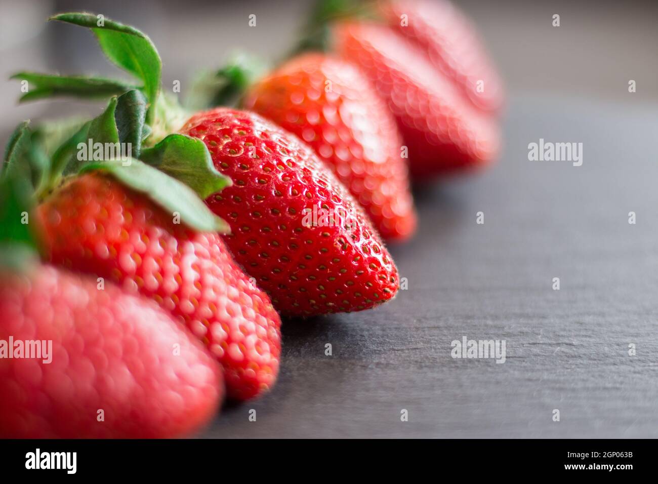 Fresh red strawberries on a black stone table Stock Photo - Alamy