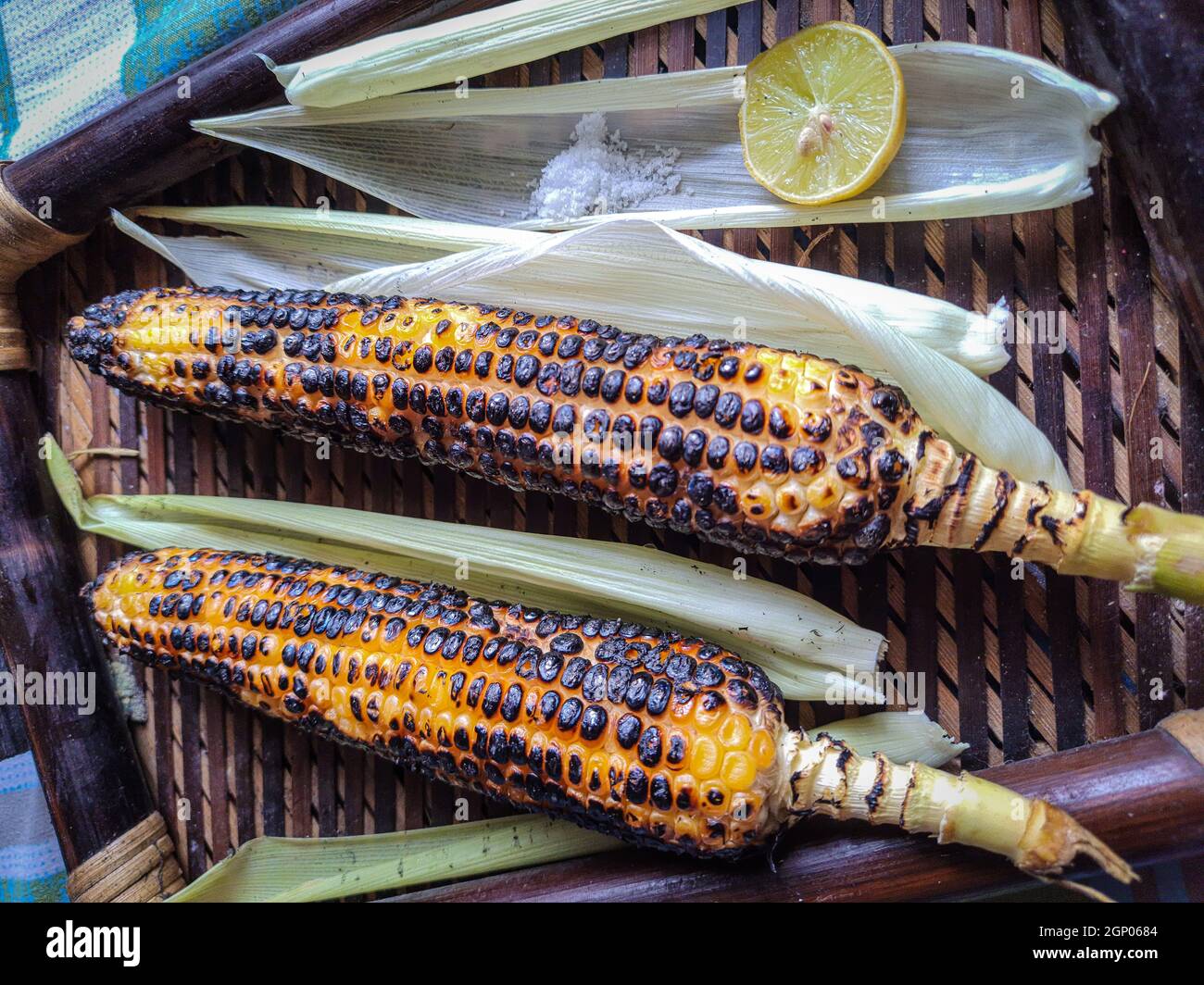 spicy sweet corn burn in fire with lemon and salt in a wood tray from