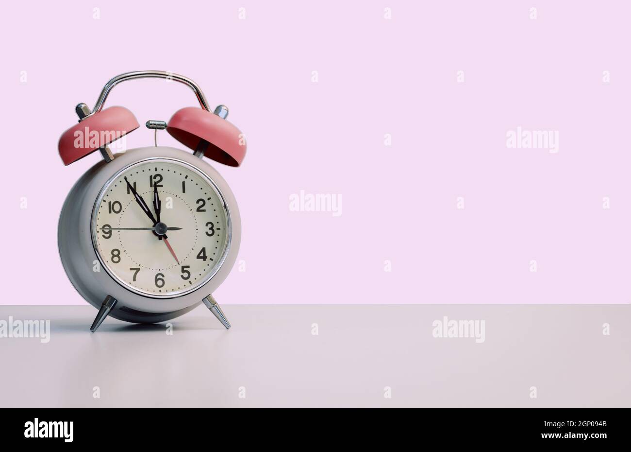 Retro styled white alarm clock, isolated and copy space, pink Stock Photo