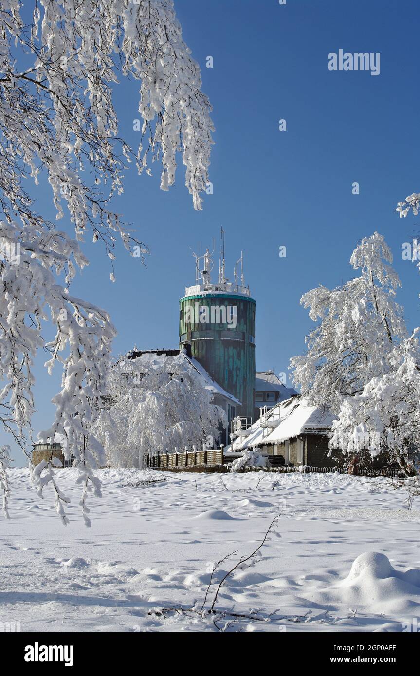 Schneebedeckte Bäume auf dem Kahlen Asten im Rothaargebirge vor blauem Winterhimmel. Im Hintergrund der Astenturm mit Hotel und der Station des Deutsc Stock Photo