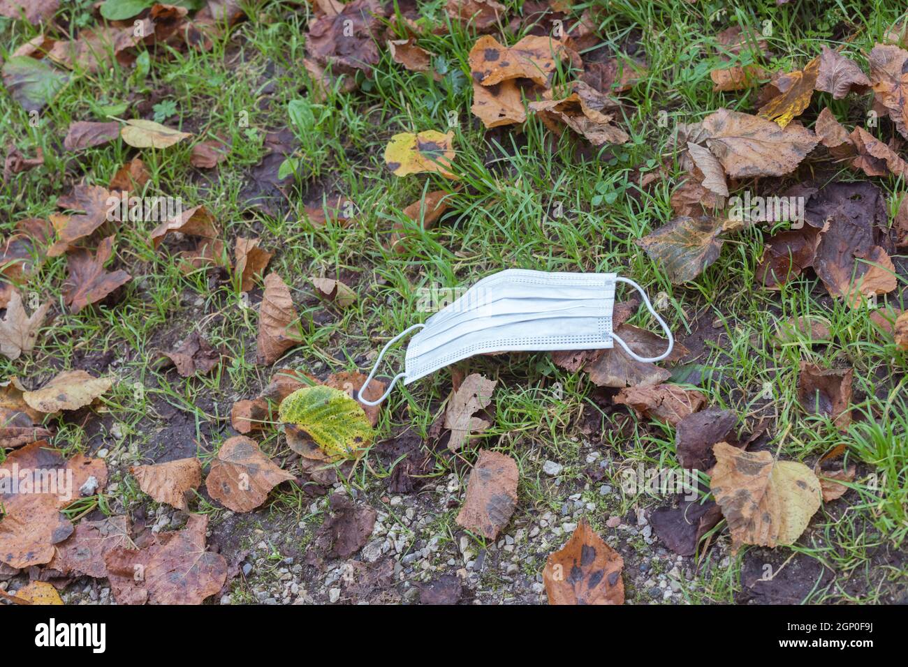 Environmental pollution concept: Single use face mask on the floor outdoors, waste Stock Photo