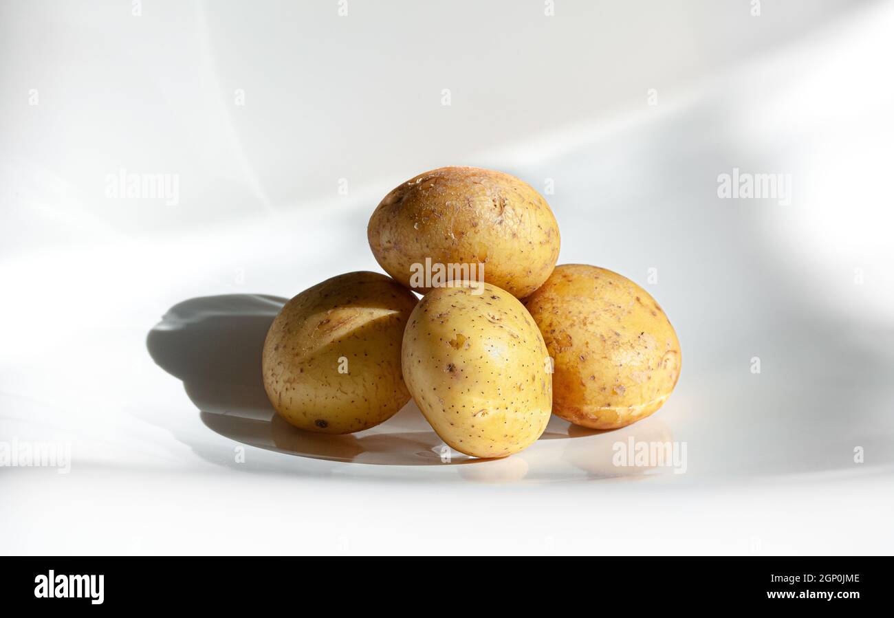 Pile of raw potatoes. White background. Stock Photo