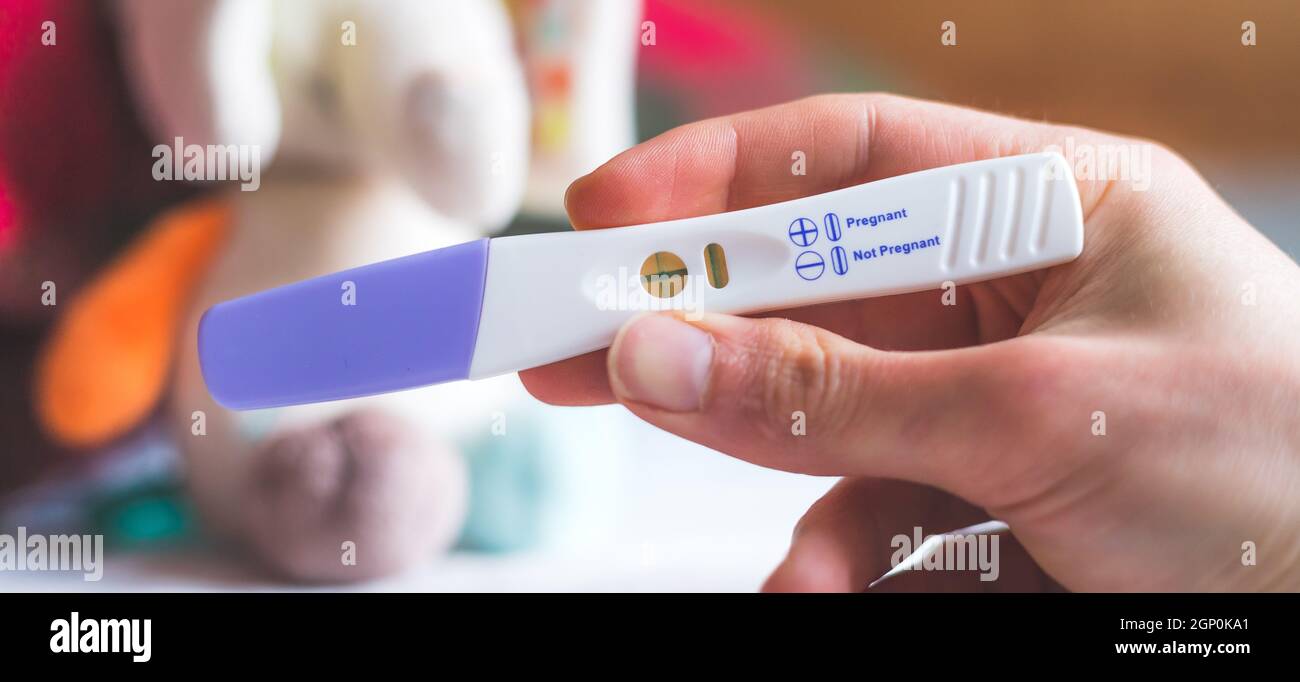 Woman hand holding pregnancy test, result is pregnant Stock Photo Alamy