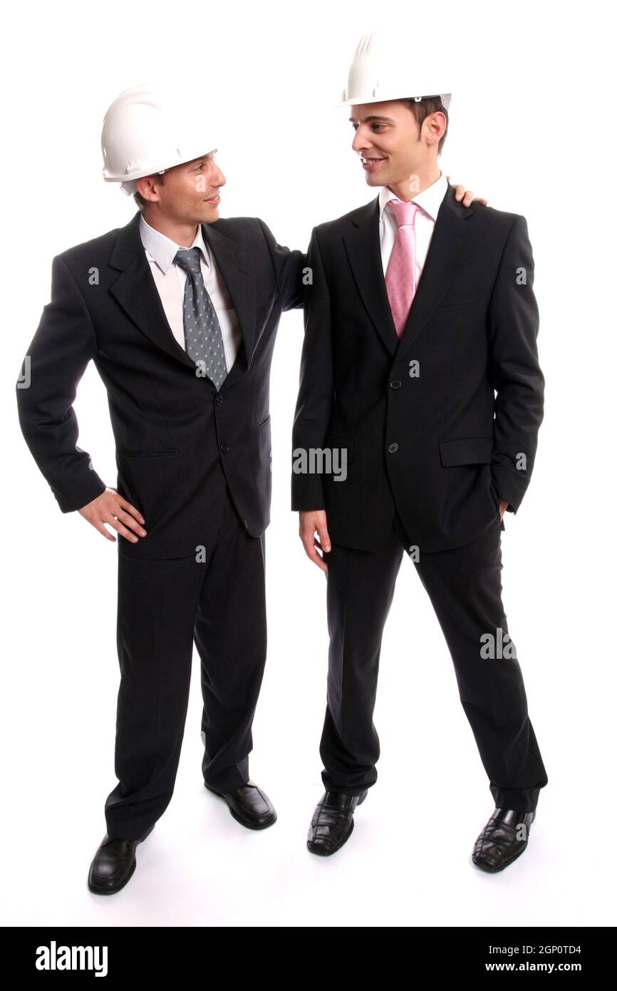 Two young Engineers closing a deal, isolated in background Stock Photo