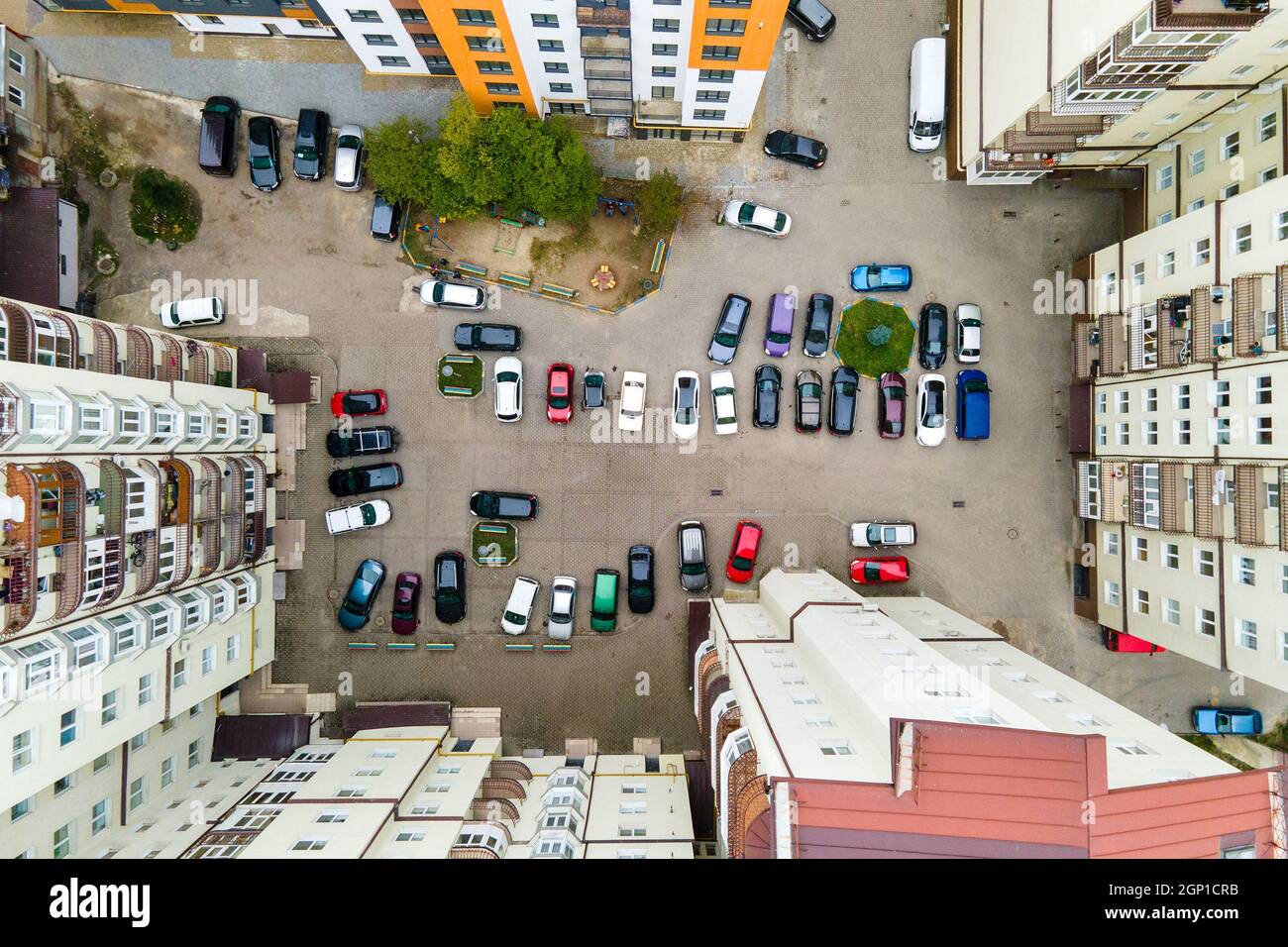 Aerial view of parked cars on parking lot between high apartment ...