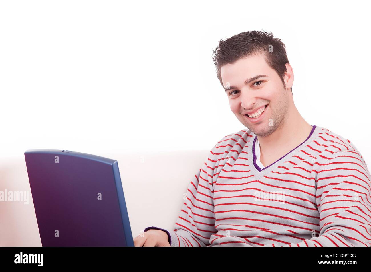 Young boy working with laptop on couch Stock Photo - Alamy
