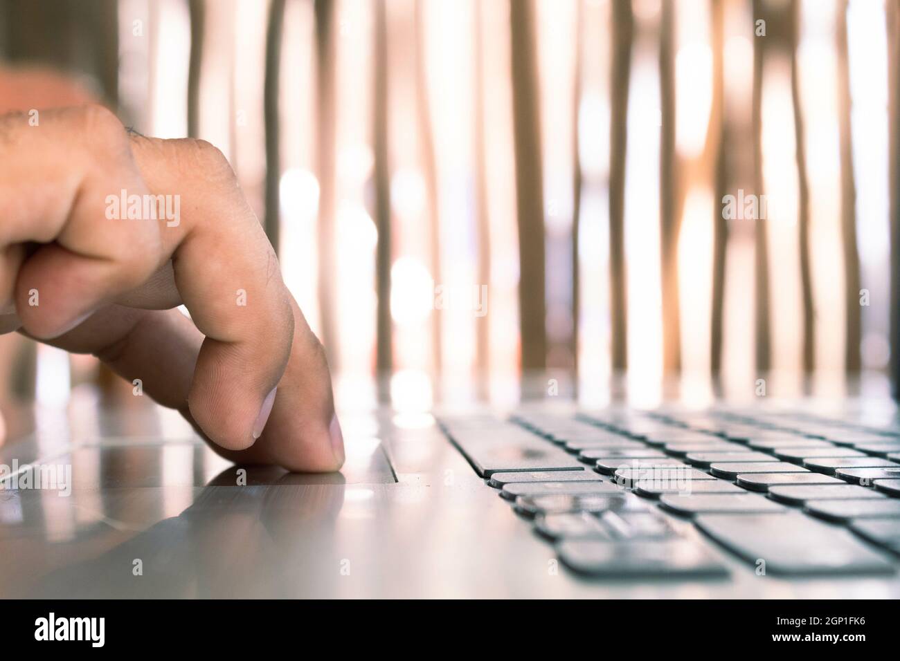 Man's hand using laptop computer in wooden house Stock Photo