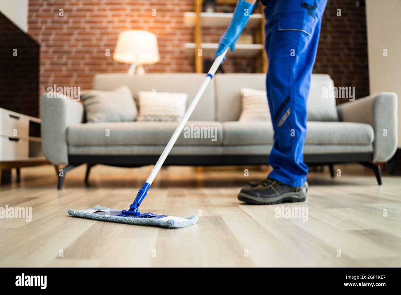 Home Floor Cleaning Service. Man Mopping Living Room Stock Photo