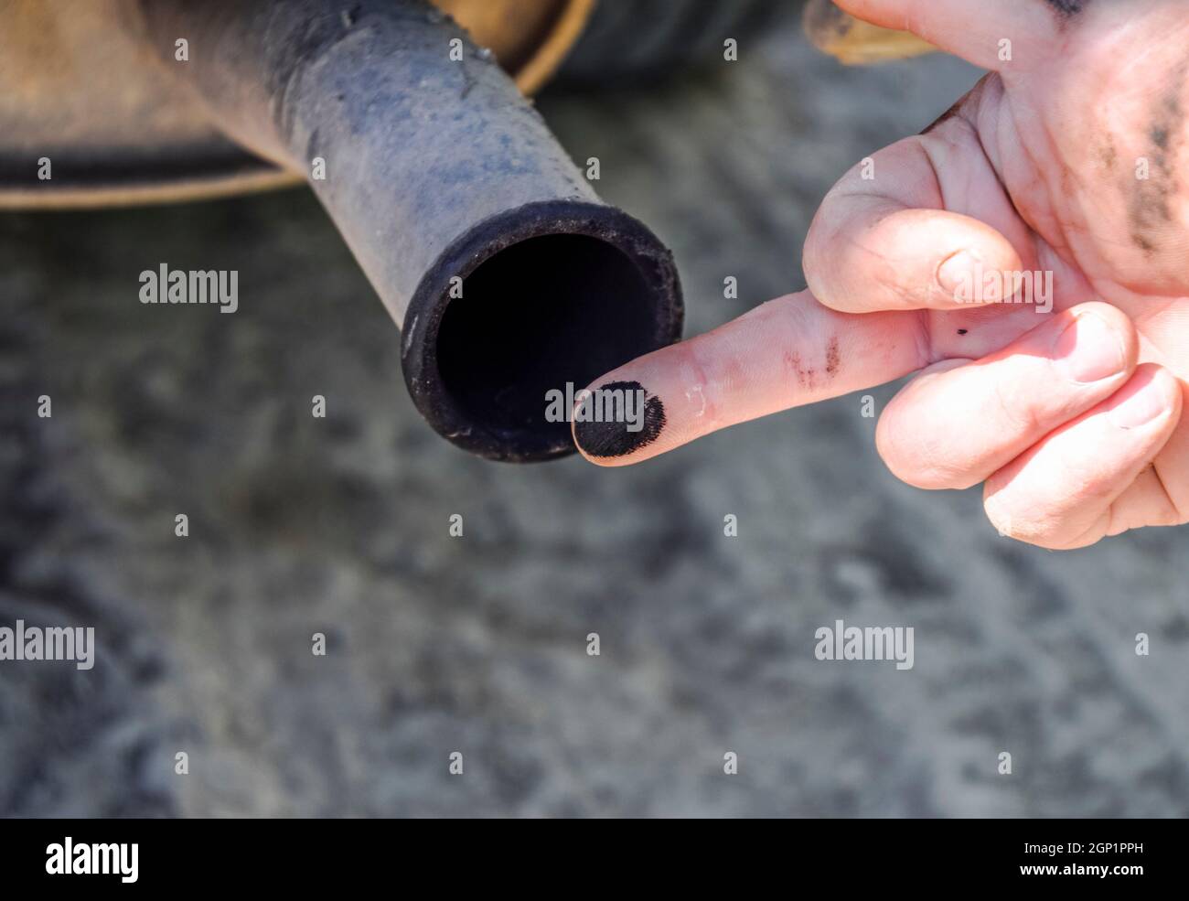 Soot from the exhaust pipe on the finger. Examination of the car's exhaust system by the