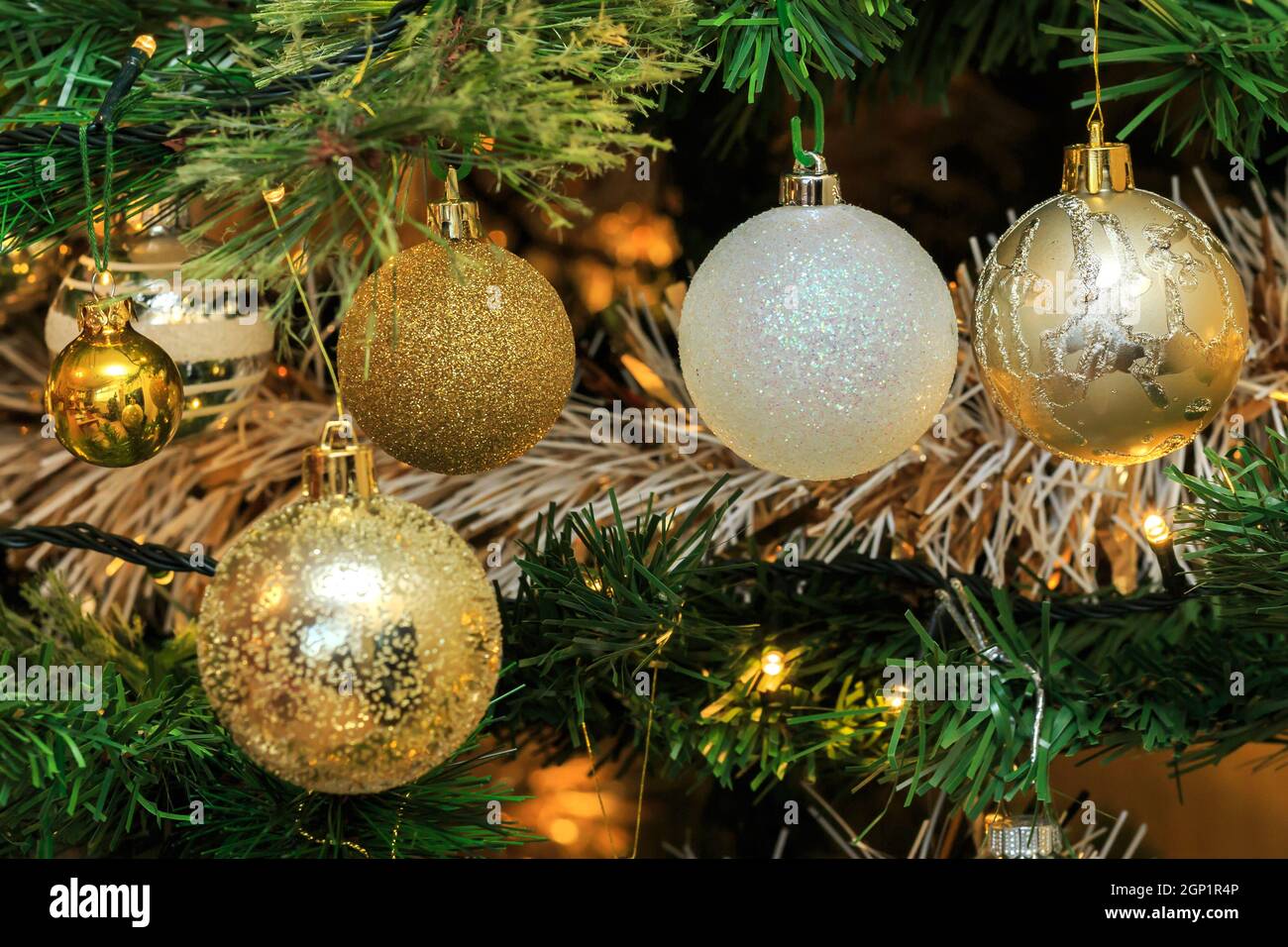 Gold and white Christmas baubles hanging Stock Photo - Alamy