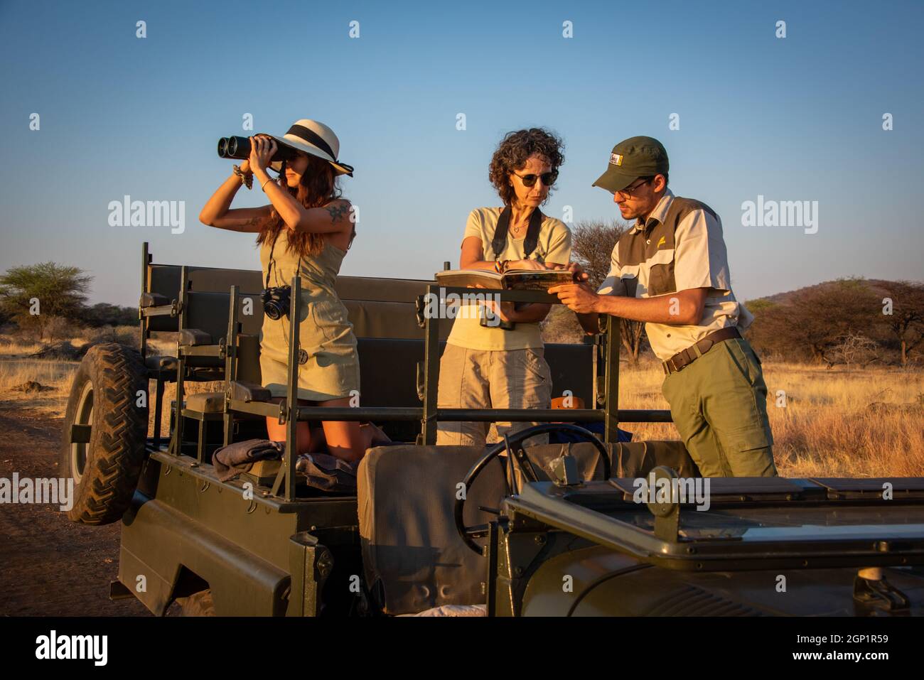 Guide and two women discuss wildlife sighting Stock Photo
