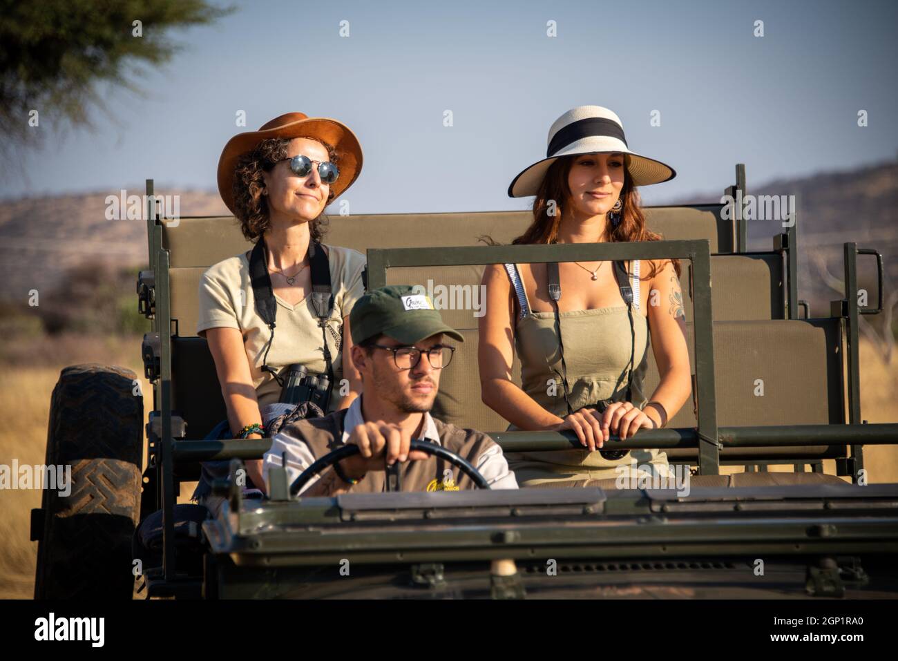 Guide driving two female guests in jeep Stock Photo