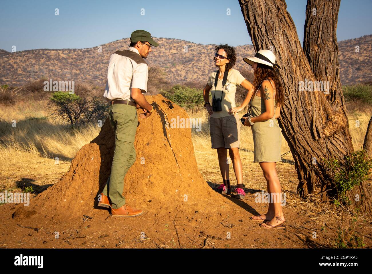 Guide explaining termite mound stain to women Stock Photo
