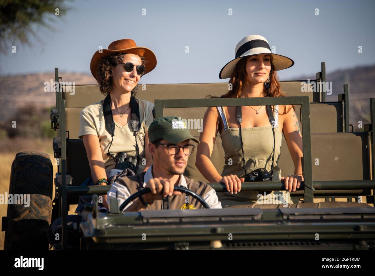 Guide drives two female guests in jeep Stock Photo