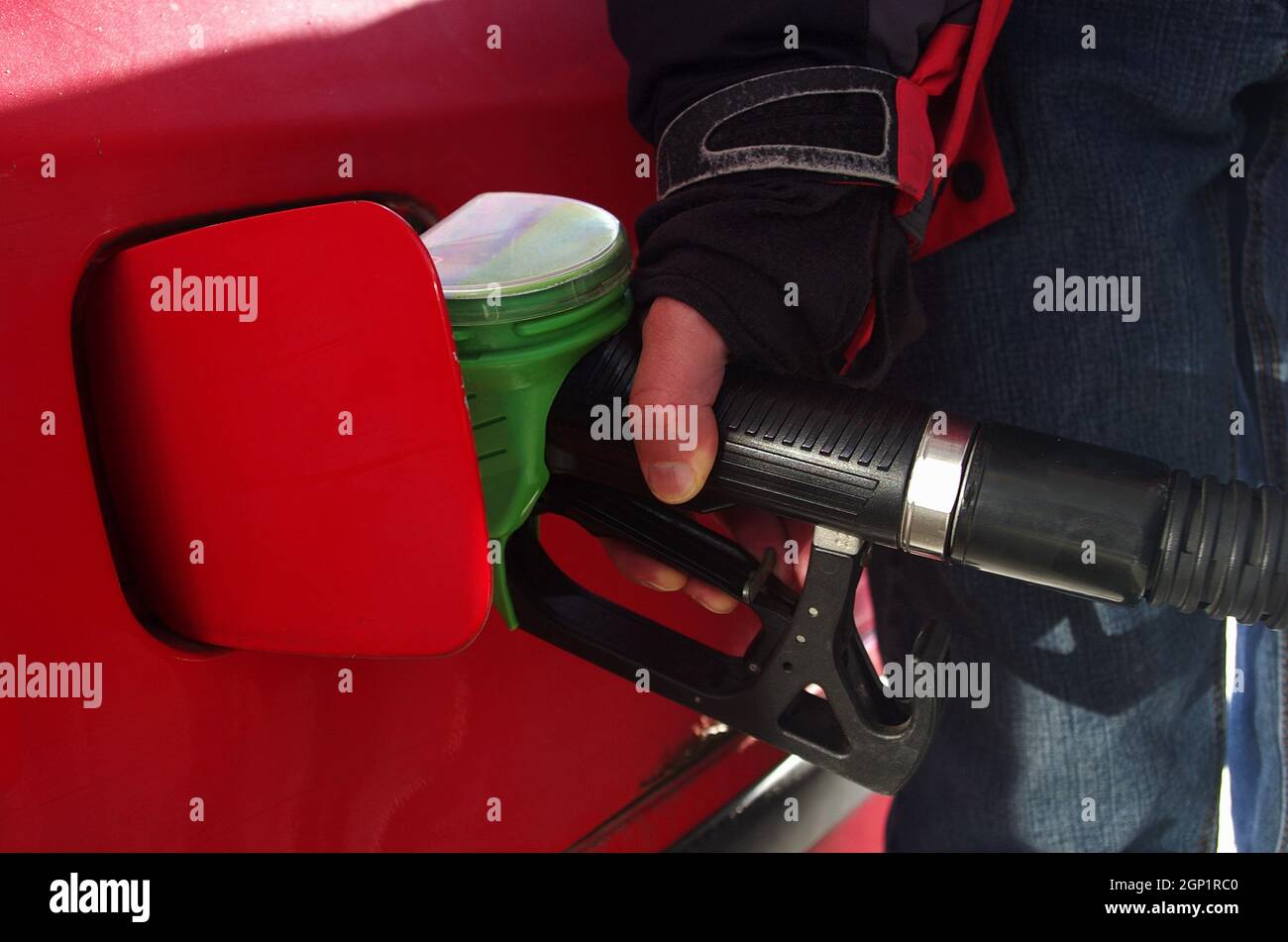 Male hand refilling the car with fuel pistol on a filling Station. Crude oil prices and gas price. The world's most expensive fuel. Stock Photo