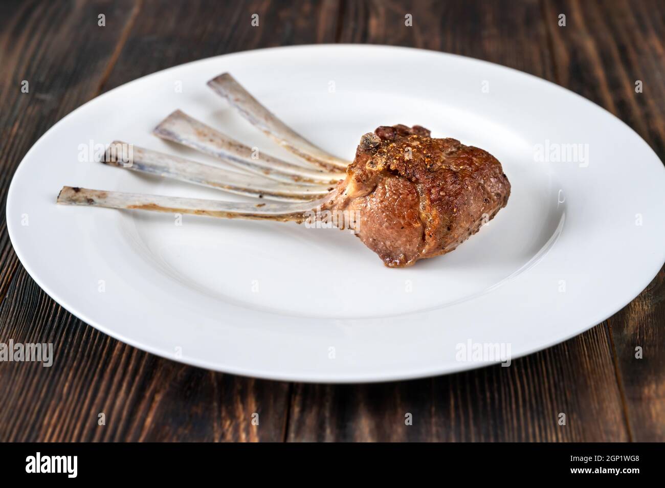 Portion of rack of lamb on white plate Stock Photo
