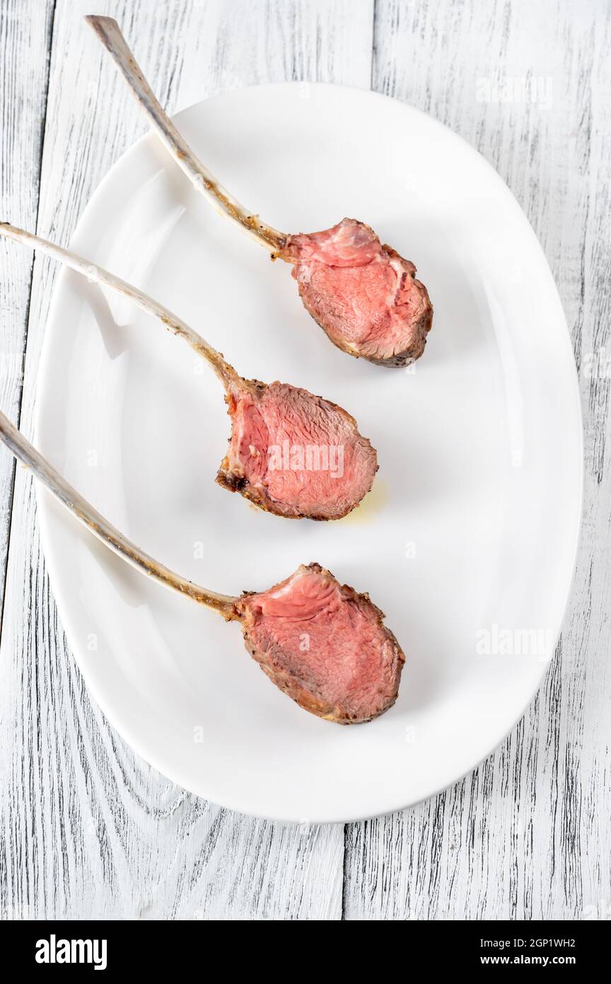 Rack of lamb on the white serving plate: top view Stock Photo
