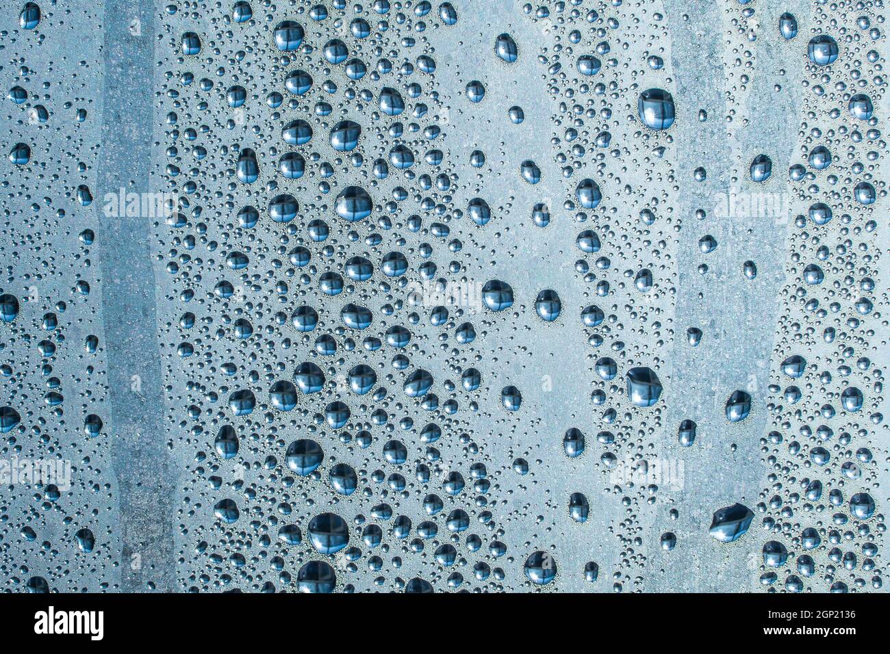 Abstract background ornament with water drops.Raindrops on the glass in rainy weather.The glittering, shiny surface of water on glass.Water drops in t Stock Photo