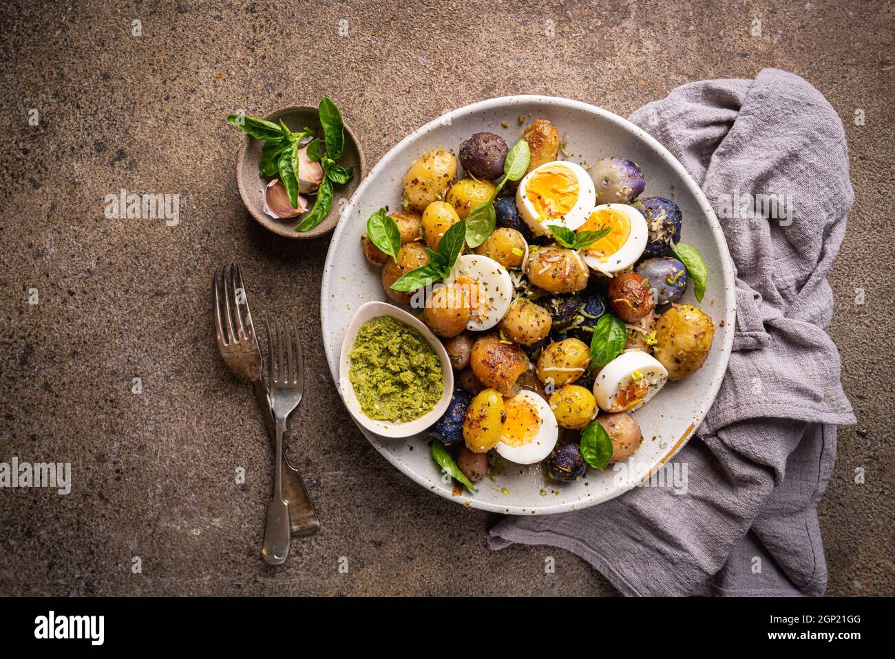 Homemade salad of new colorful potatoes, quail eggs and pesto, top view