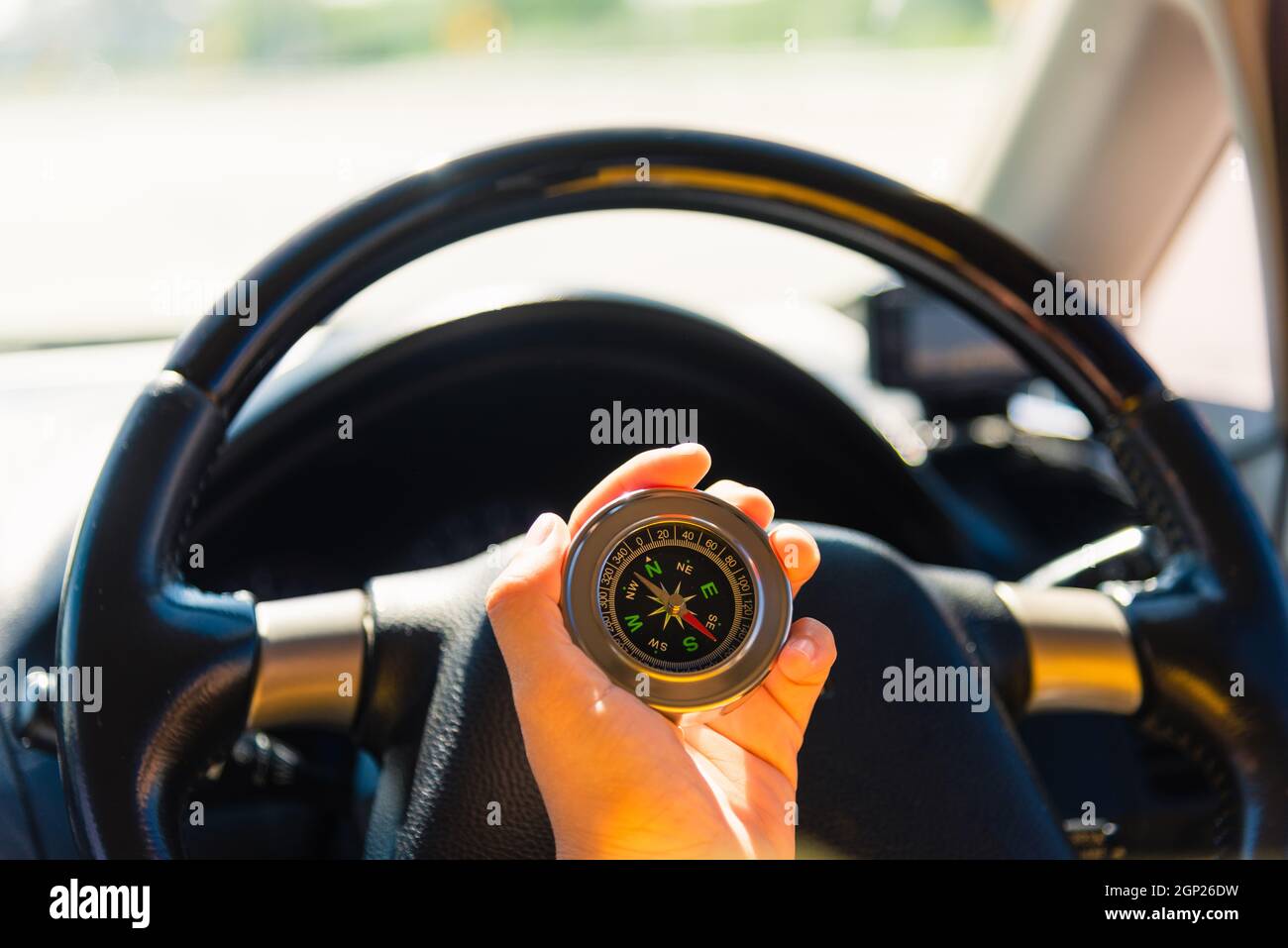 Asian woman inside a car and using compass to navigate while driving