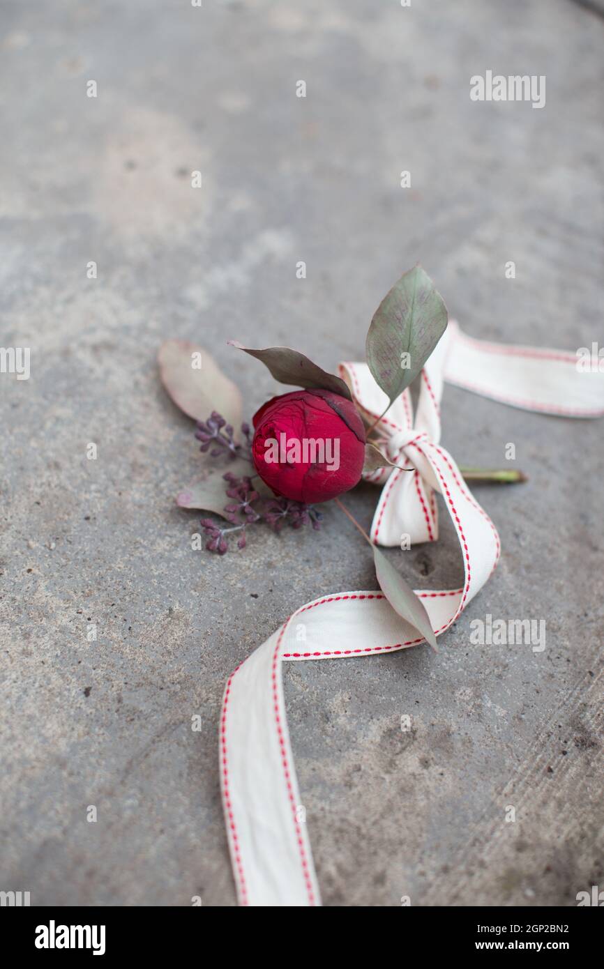 Red rose with ribbon on the concrete ground. High quality photo Stock Photo