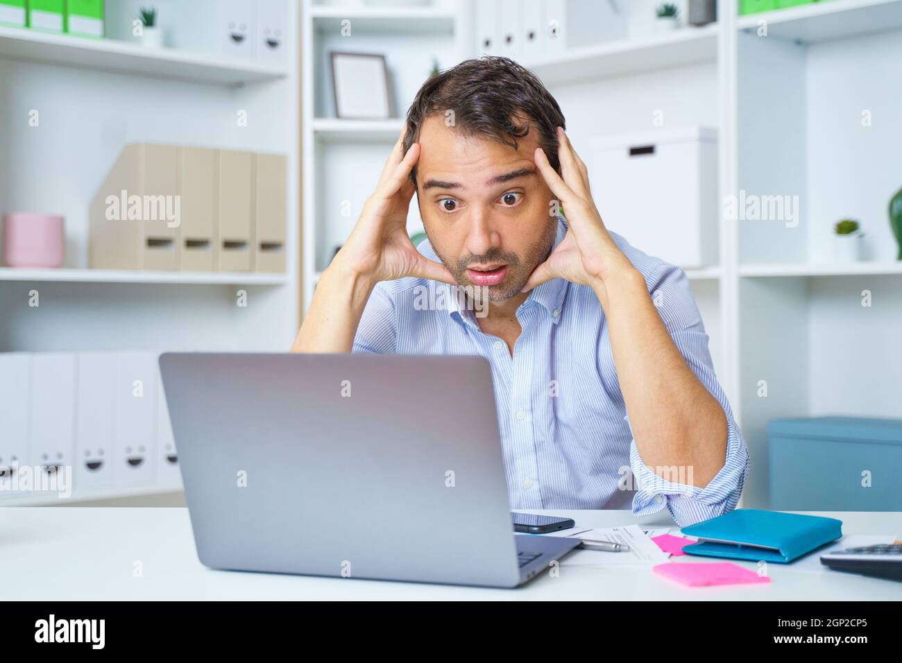 Frustrated man confused and surprised by an unexpected error working on computer Stock Photo
