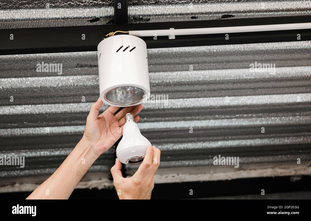 Close up human hand is installing an LED light bulb in a circular ...