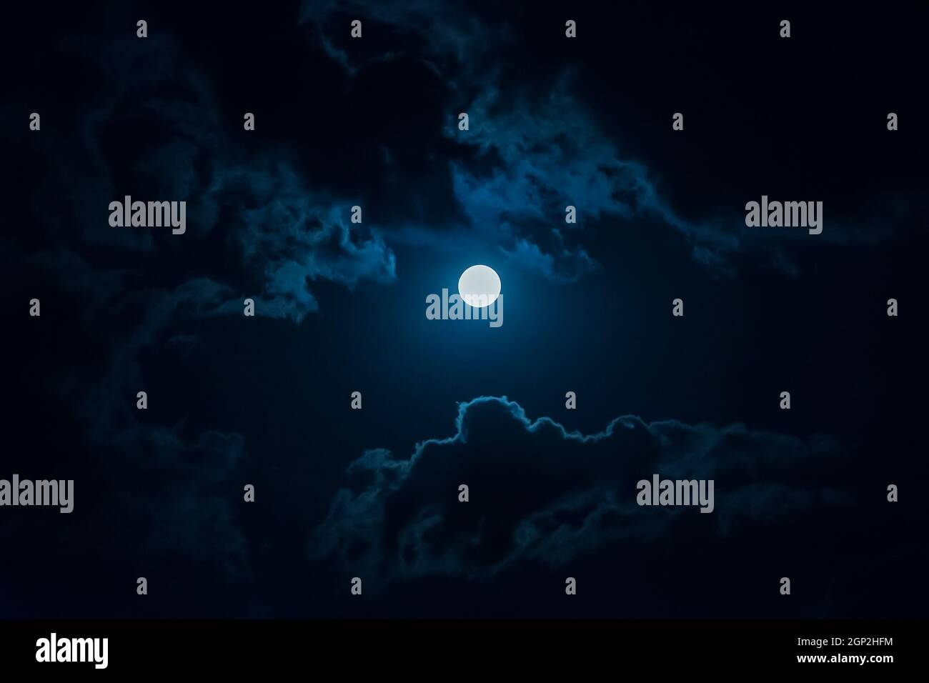 A full moon in the night sky among the clouds Stock Photo - Alamy