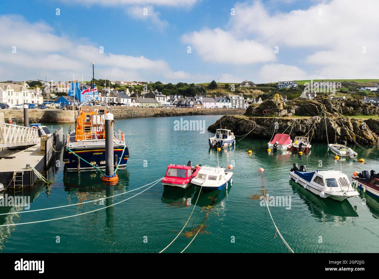 RNLI Lifeboat and small boats moored in natural harbour in west coast fishing village. Portpatrick, Dumfries and Galloway, Scotland, UK, Britain Stock Photo