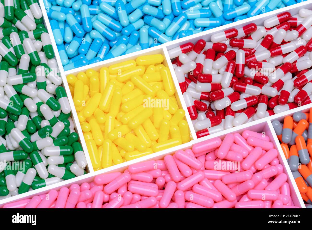 Above view capsule pills in plastic box. Multi colored capsule pills. Vitamin and supplement