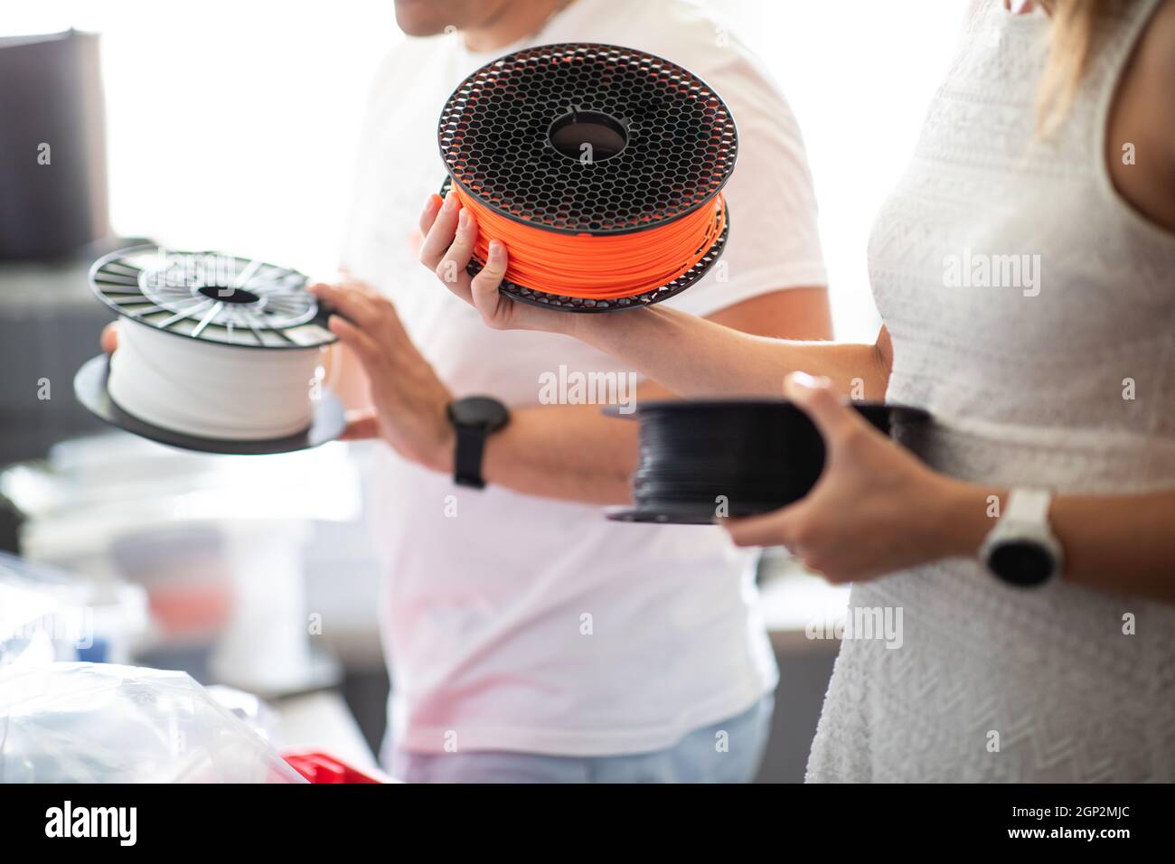 3D Printer Plastic filament for 3D printer and printed products in the hands of a young man Stock Photo