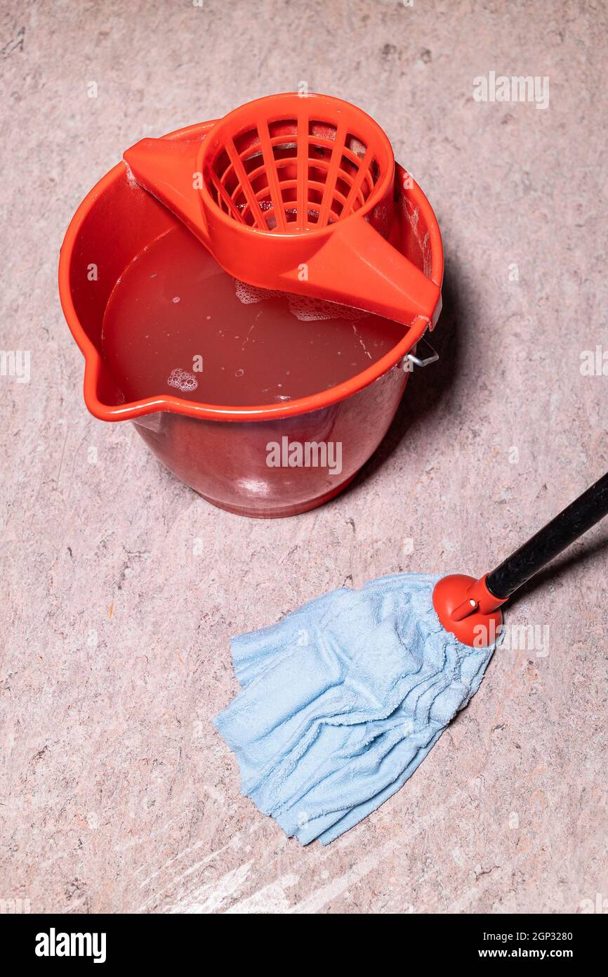 above view of mop cleaning linoleum flooring near red bucket with dirty