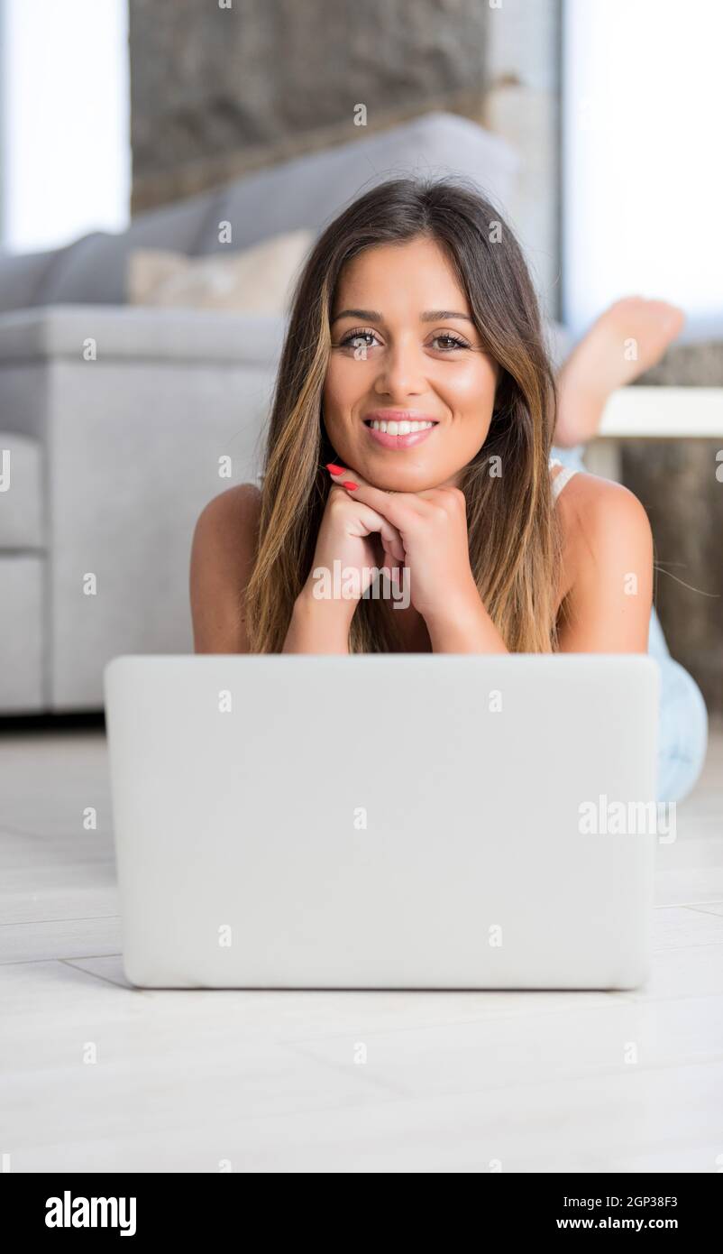 Beautiful young woman relaxing at home on her laptop computer Stock ...