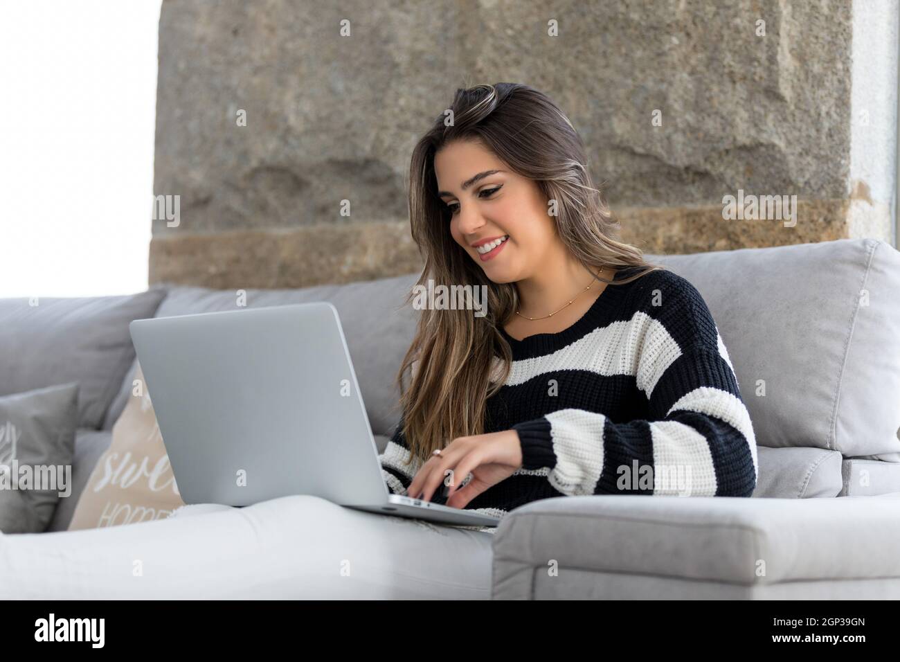 Beautiful young woman relaxing at home on her laptop computer Stock ...
