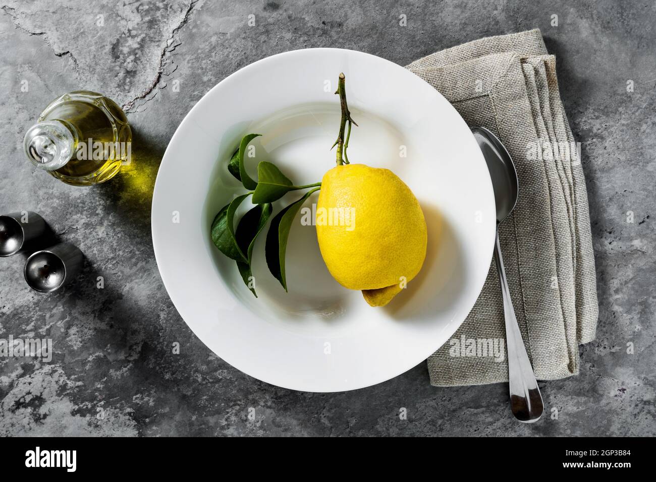 lemon on a plate. table setting. tableware. cutlery. on a dark background Stock Photo