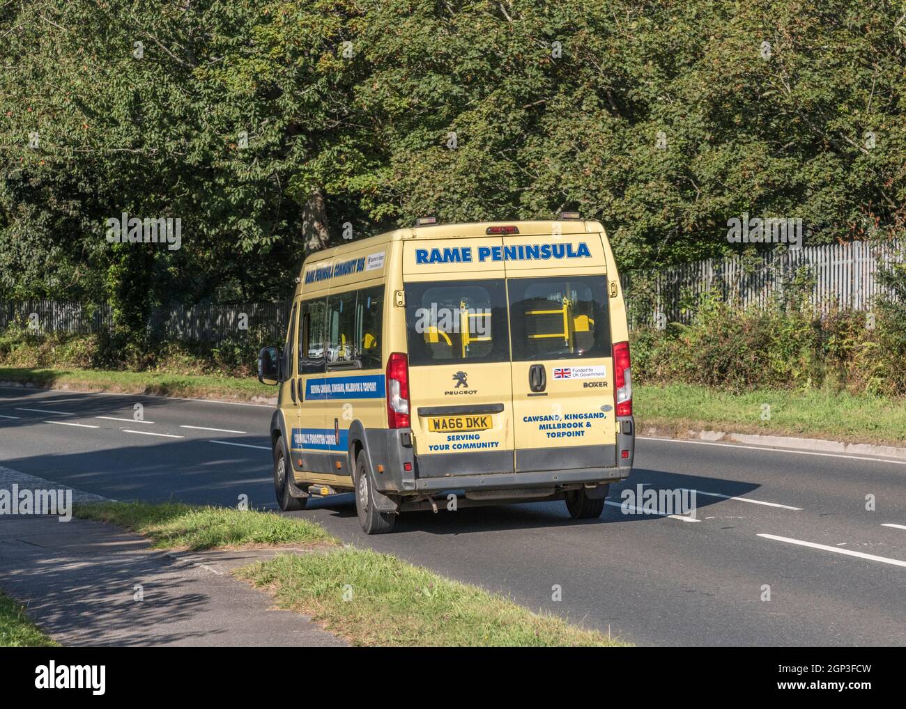 Local Rame Peninsula communiy minibus travelling downhill on a country road. For local community transport schemes, getting around the country. Stock Photo