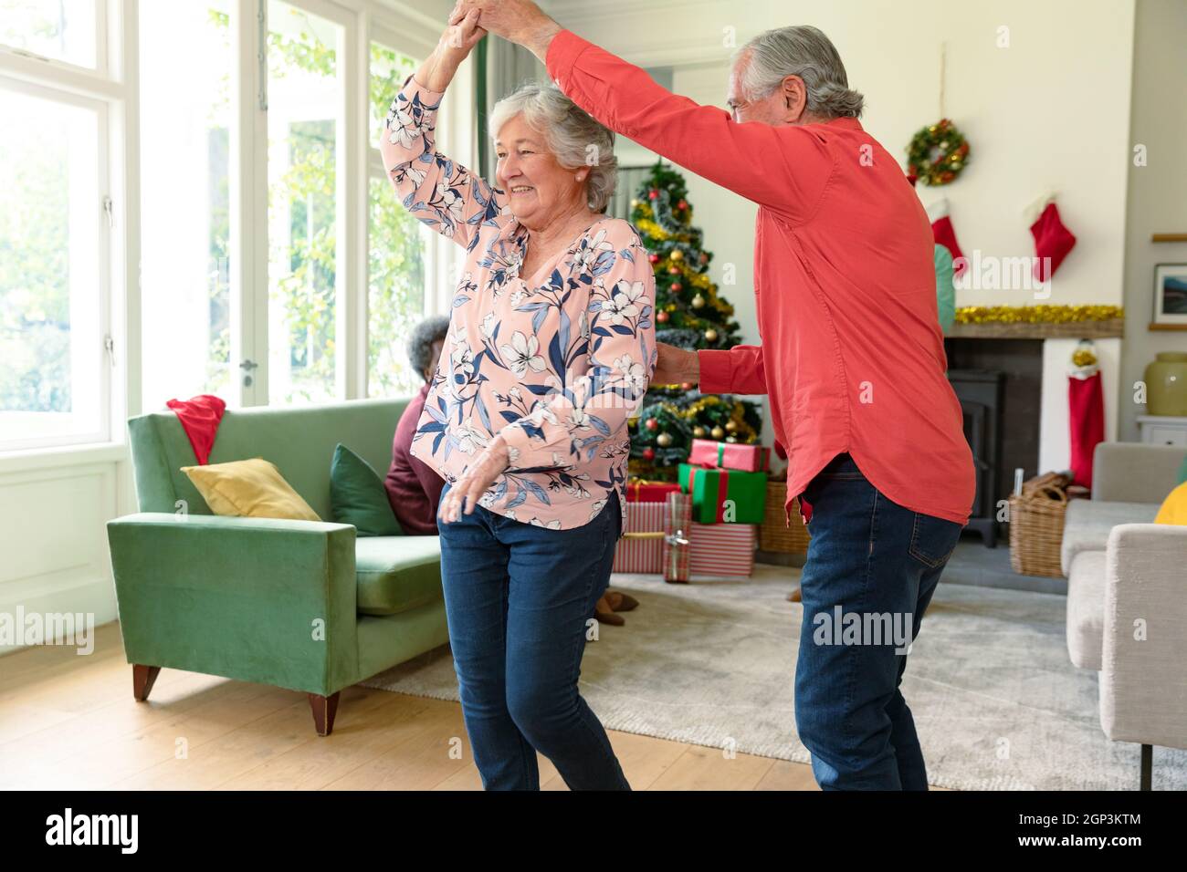 Happy caucasian senior couple dancing in living room at christmas time Stock Photo