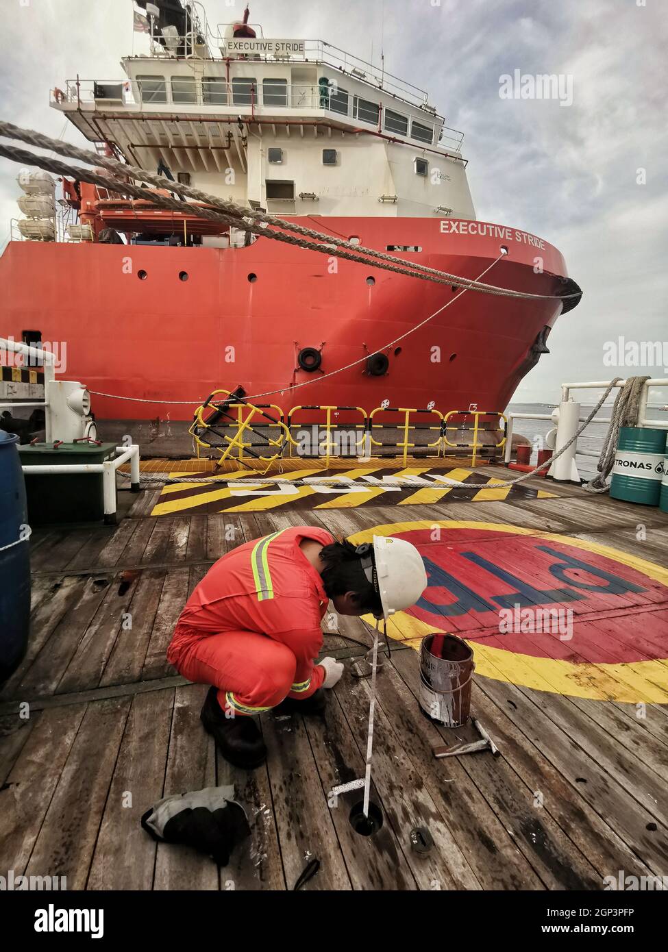 engine marine crew sounding fuel oil during bunkering at port with complete PPE personal protection equipment Stock Photo