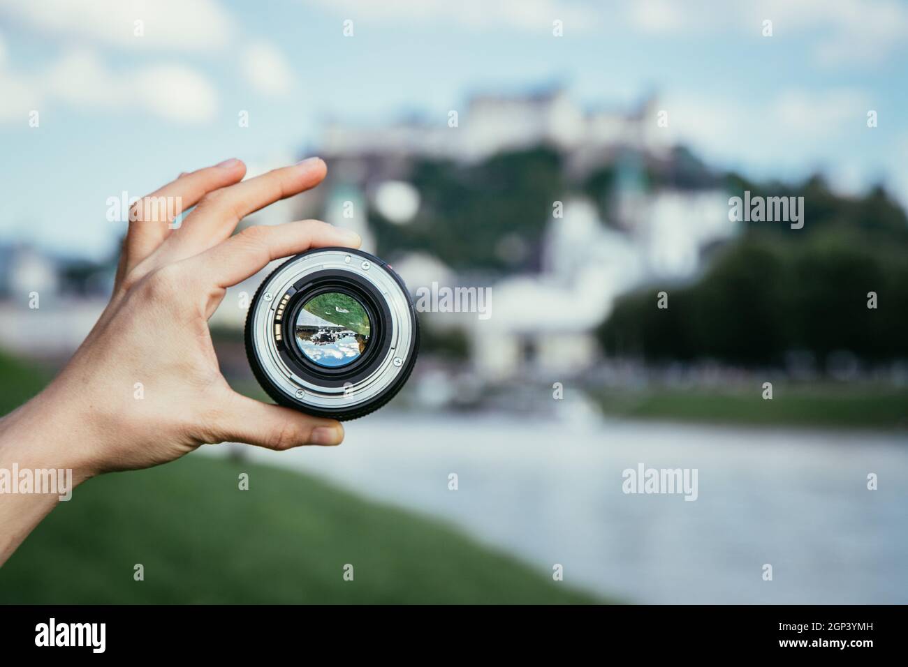 Hand holding camera lens with old city of Salzburg in it, close up ...