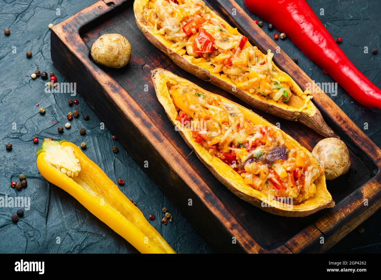 Baked yam with peppers,quinoa and mushrooms.Batata halves stuffed with vegetables Stock Photo