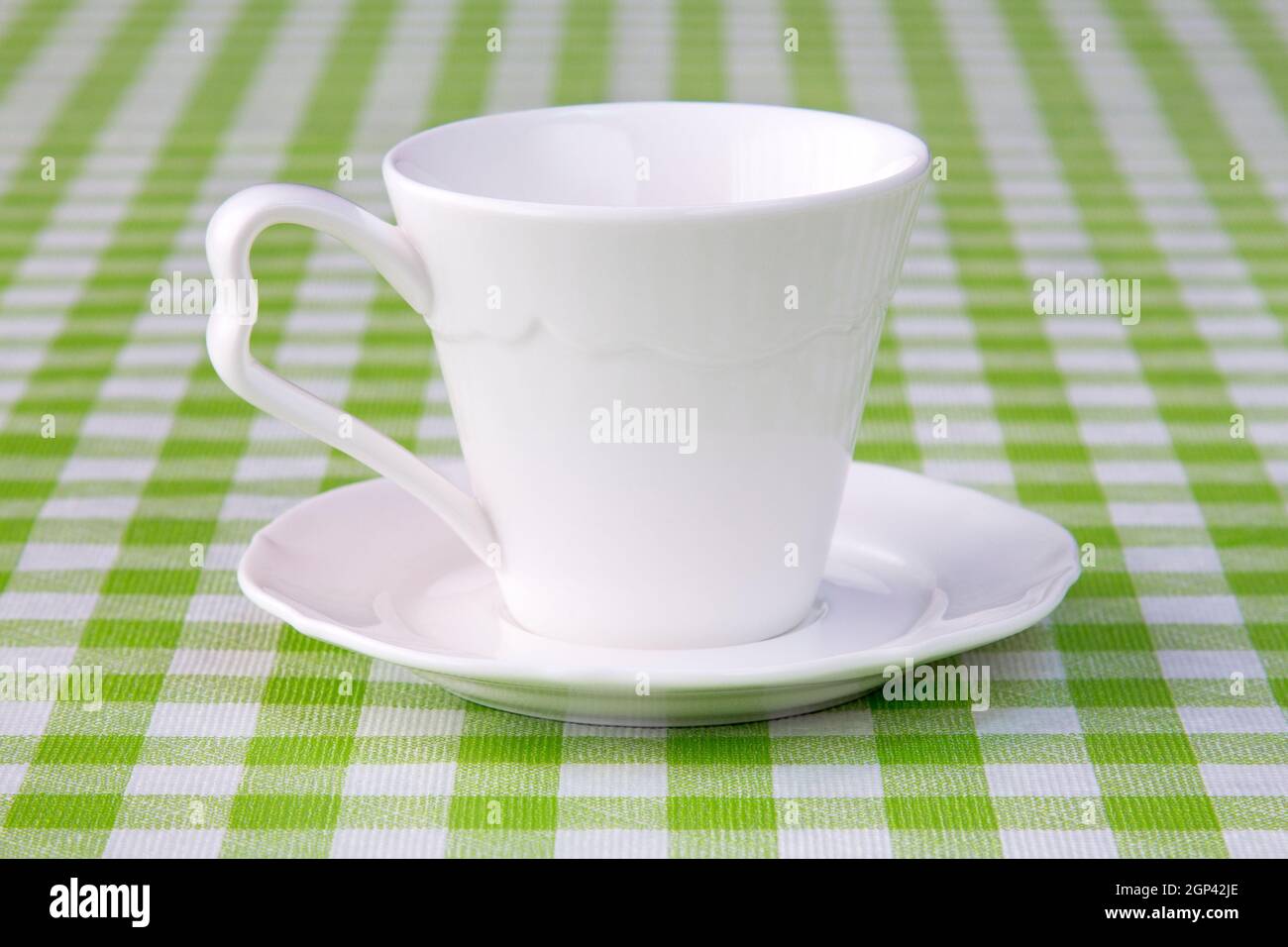 Empty cup on the checkered tablecloth texture Stock Photo