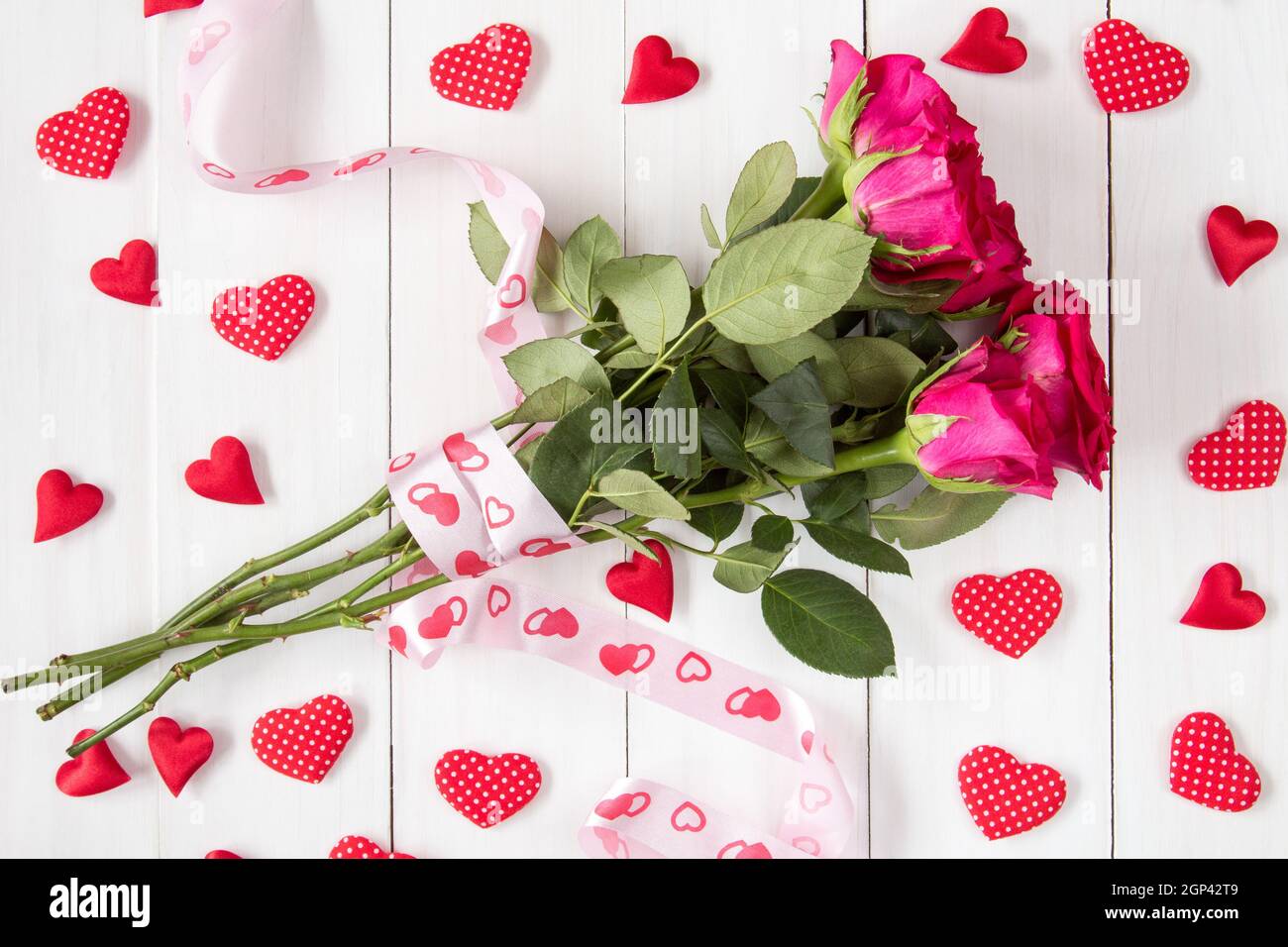 Bouquet of red roses with ribbon and many decorative hearts Stock Photo ...