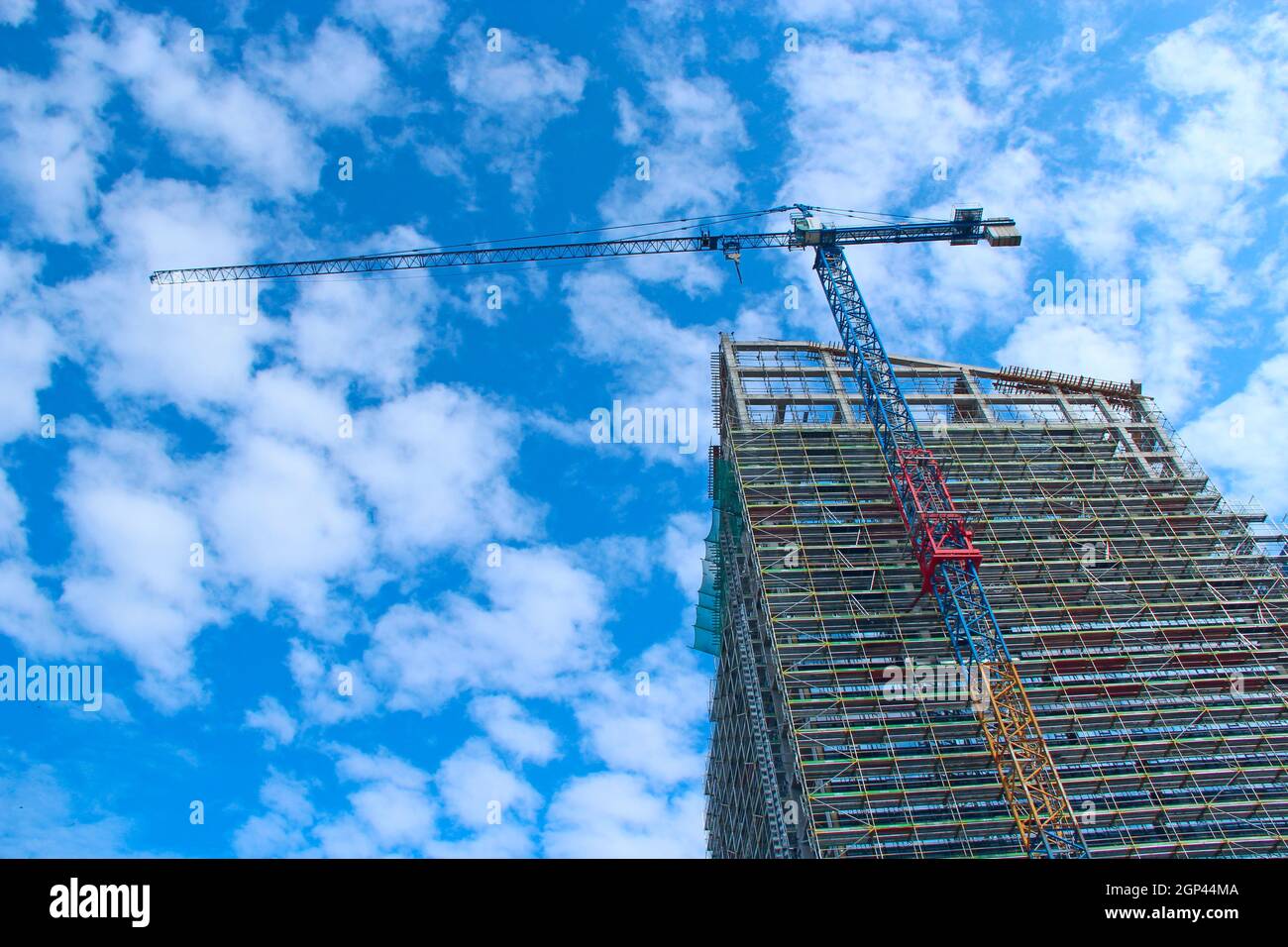 Construction crane lifting load during construction of multistorey
