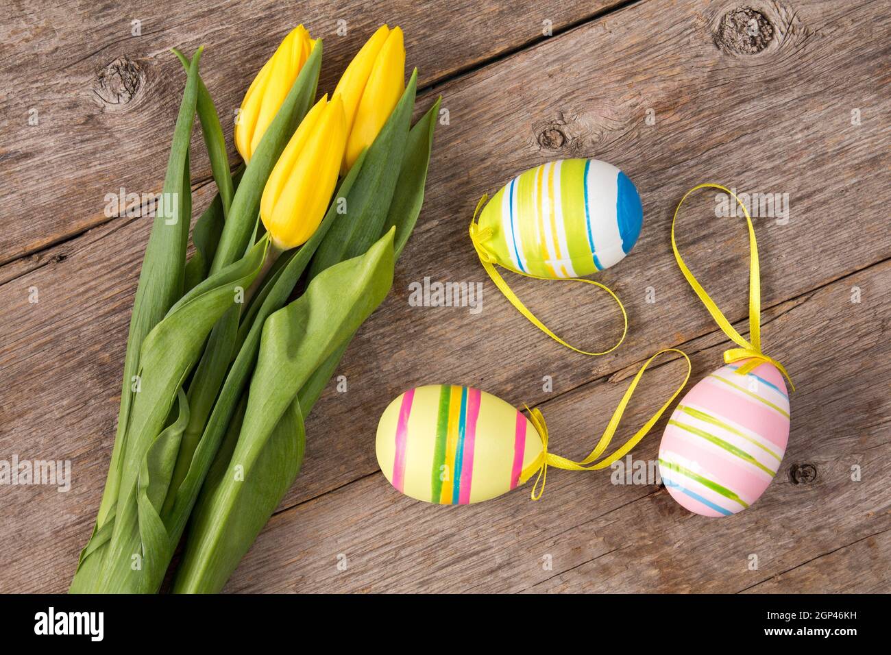 Three yellow tulips and three Easter eggs Stock Photo - Alamy